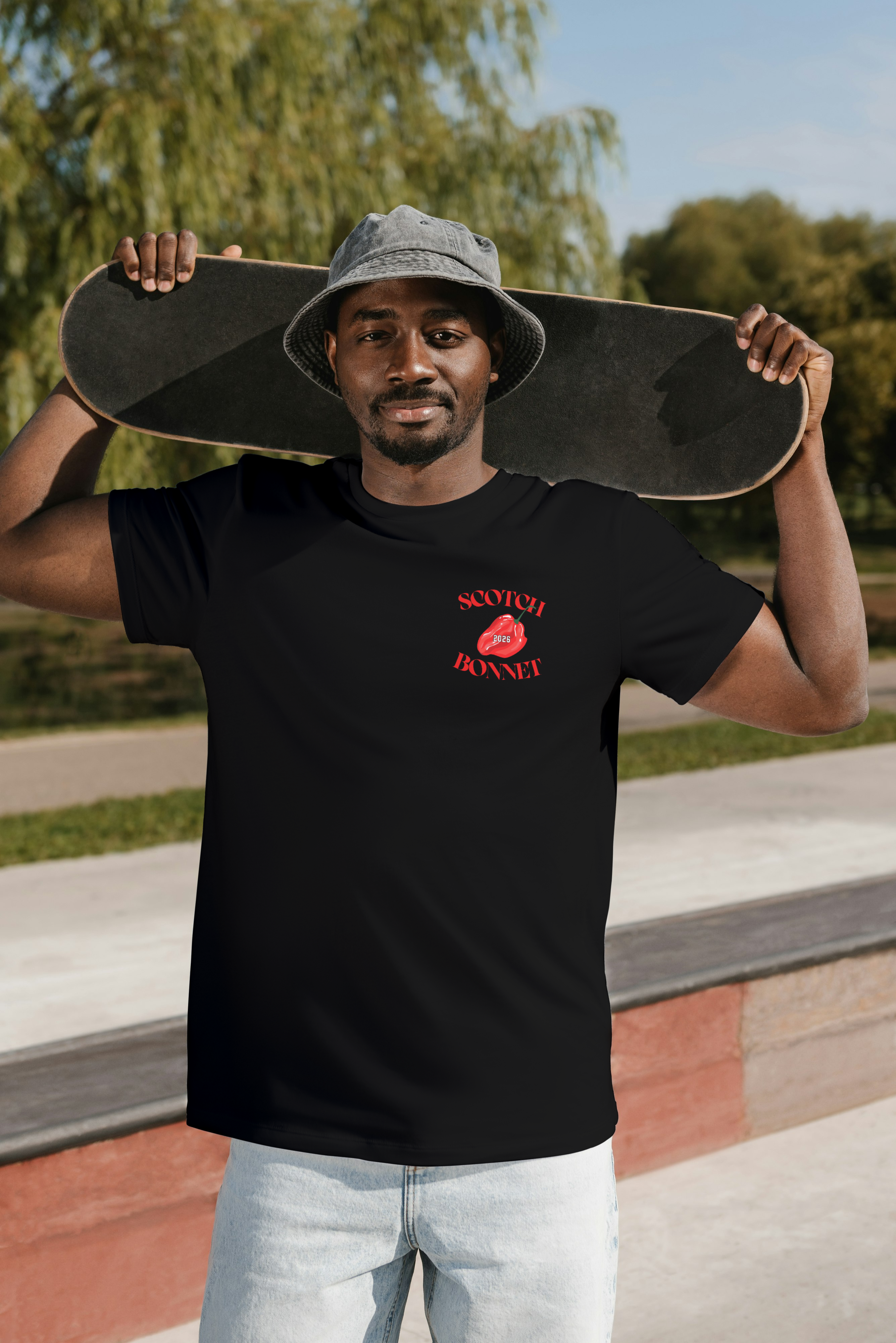 Man wearing black Scotch & Bonnet classic small face logo t-shirt at skate park